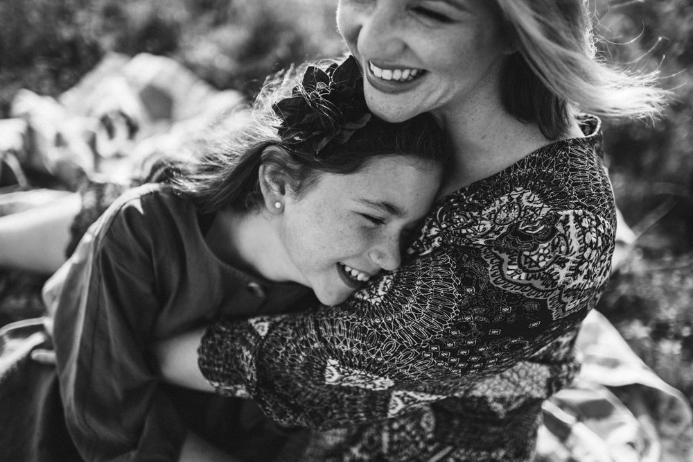 Mother and daughter hugging and laughing black and white
