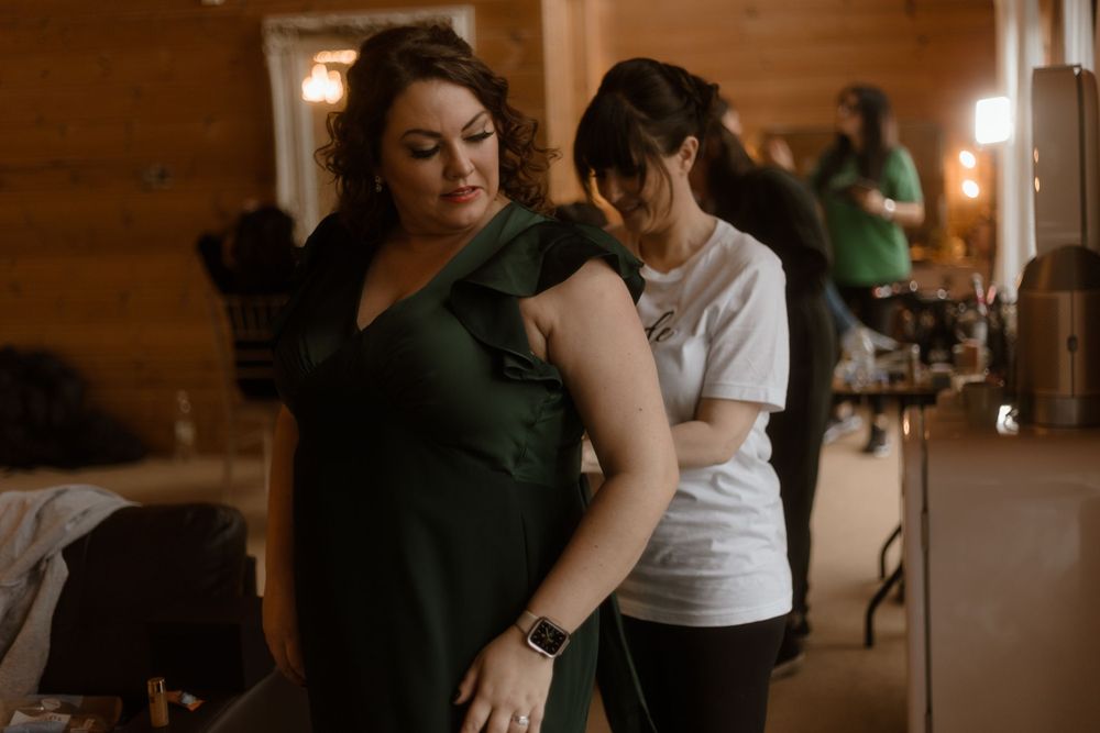 Wedding preparation scene showing bridesmaids in a rustic wooden interior.