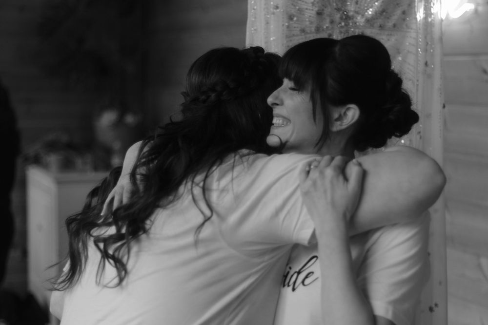 An emotional black and white moment of embrace during wedding preparations.