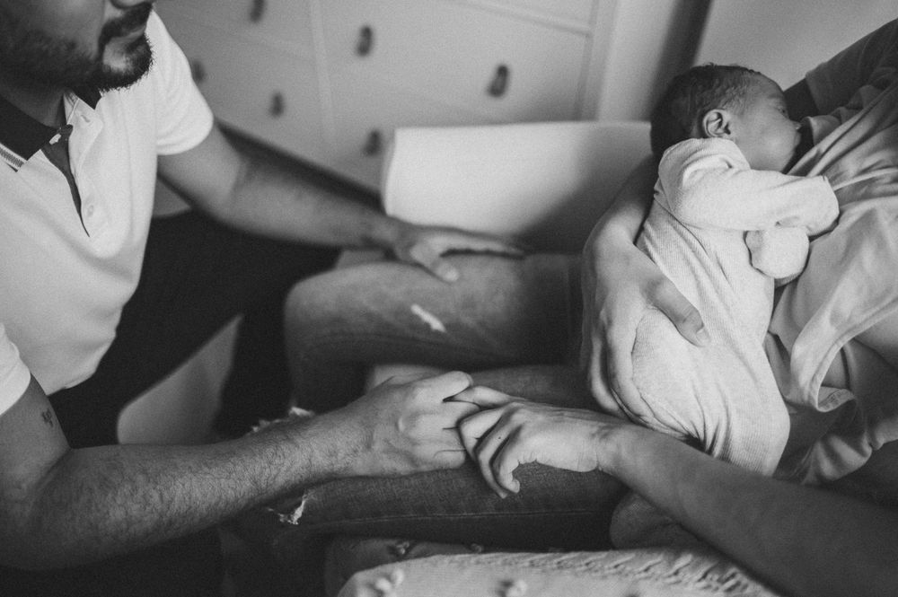 Intimate black and white photo of tender newborn care moment.
