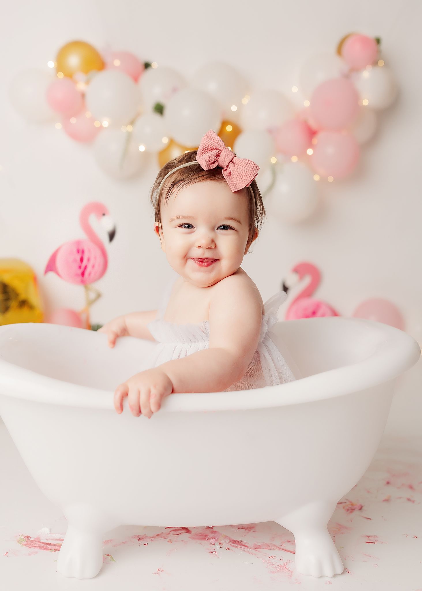 baby girl in her splash bath after her cake smash in tulsa