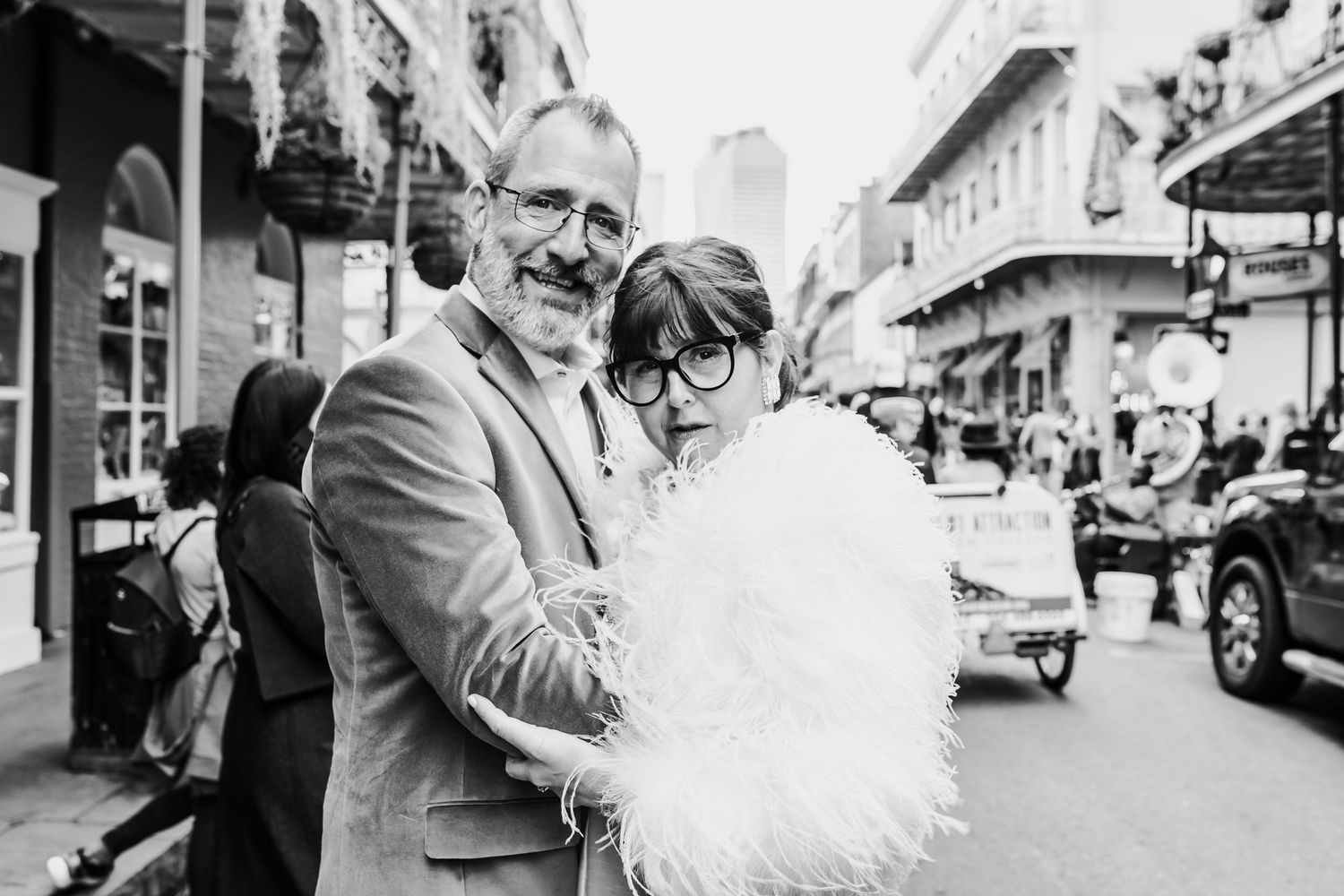 A black and white photo capturing a joyful embrace on a city street.