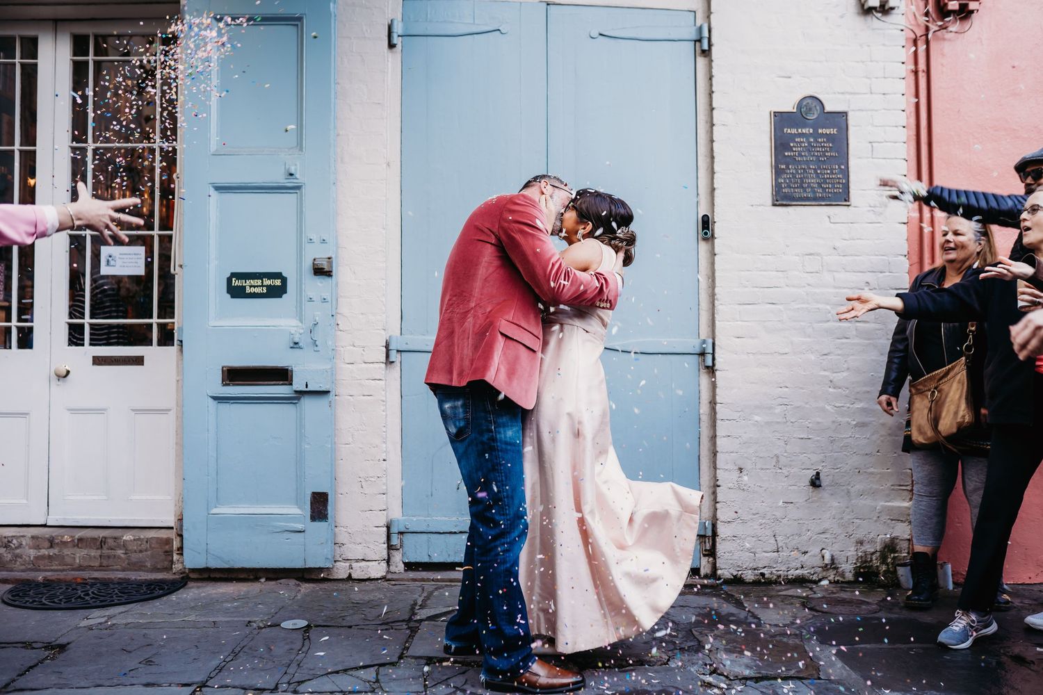 Romantic moment against colorful building facade with blue door.