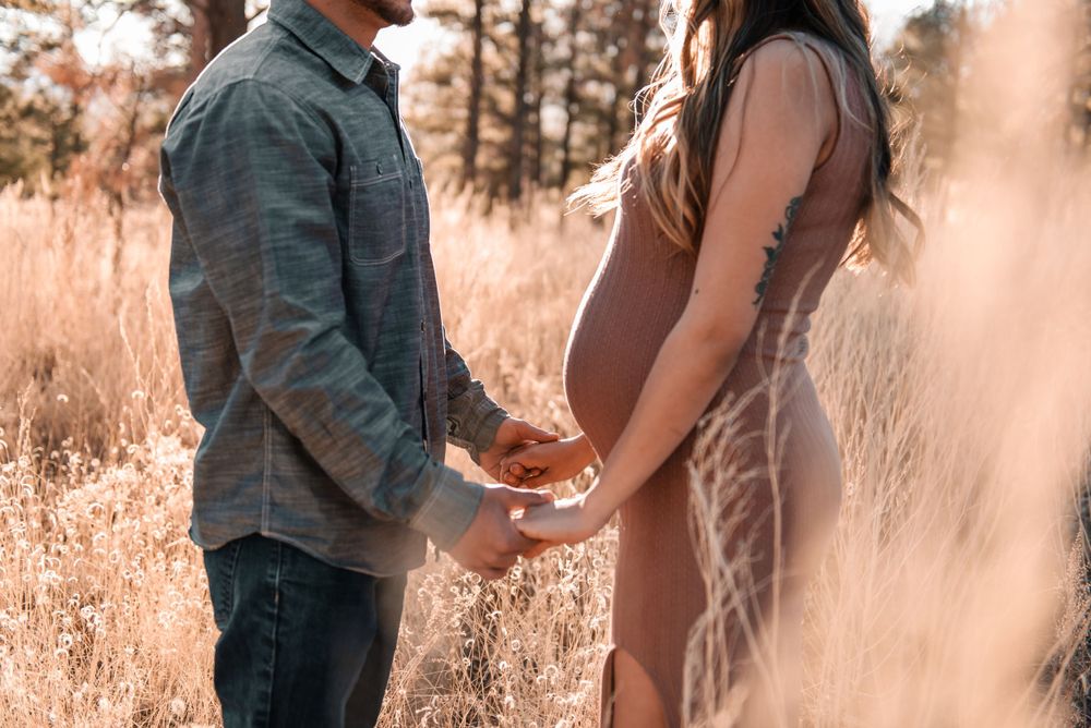 Candid moments between couple during outdoor maternity photoshoot.