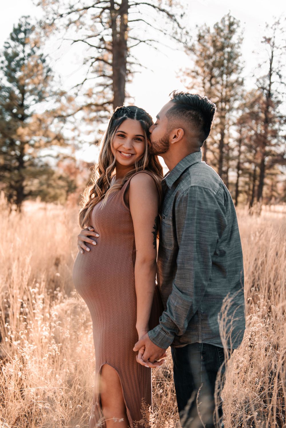 Intimate maternity portraits captured in rustic outdoor setting with natural lighting.