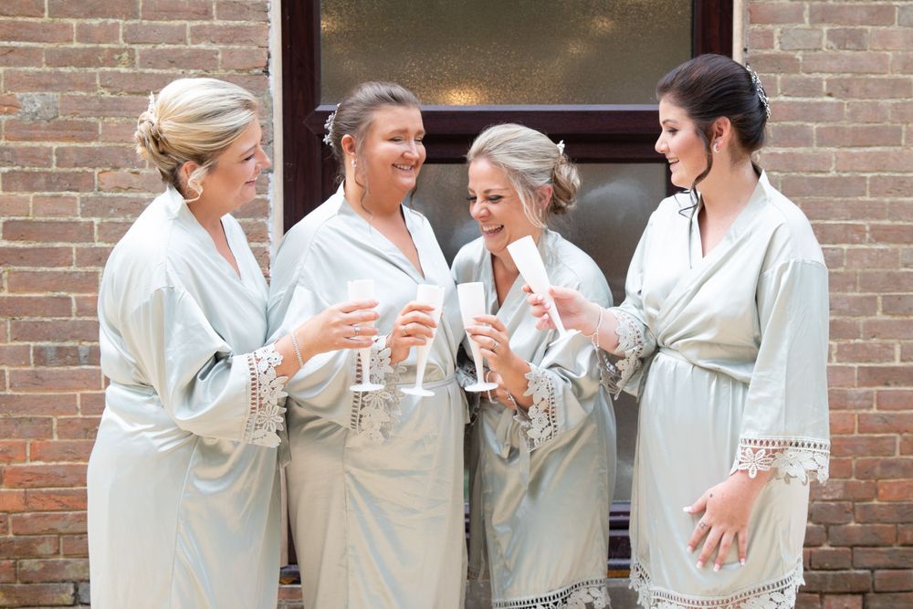 Group celebrating with champagne while wearing matching robes.