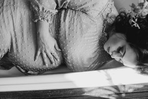 Black and white artistic boudoir photo with dramatic shadows.