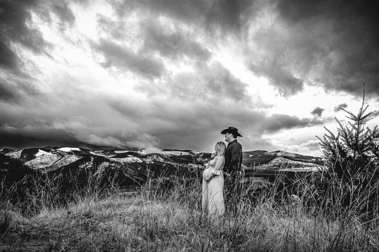 Black and white panoramic view of mountains with dramatic cloud formations.