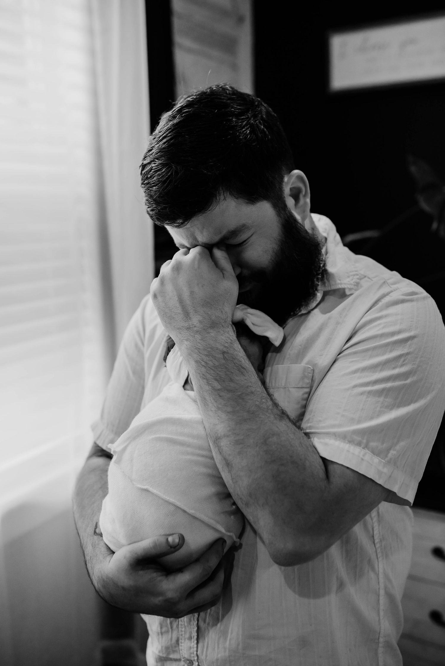 Crying Father holding newborn child