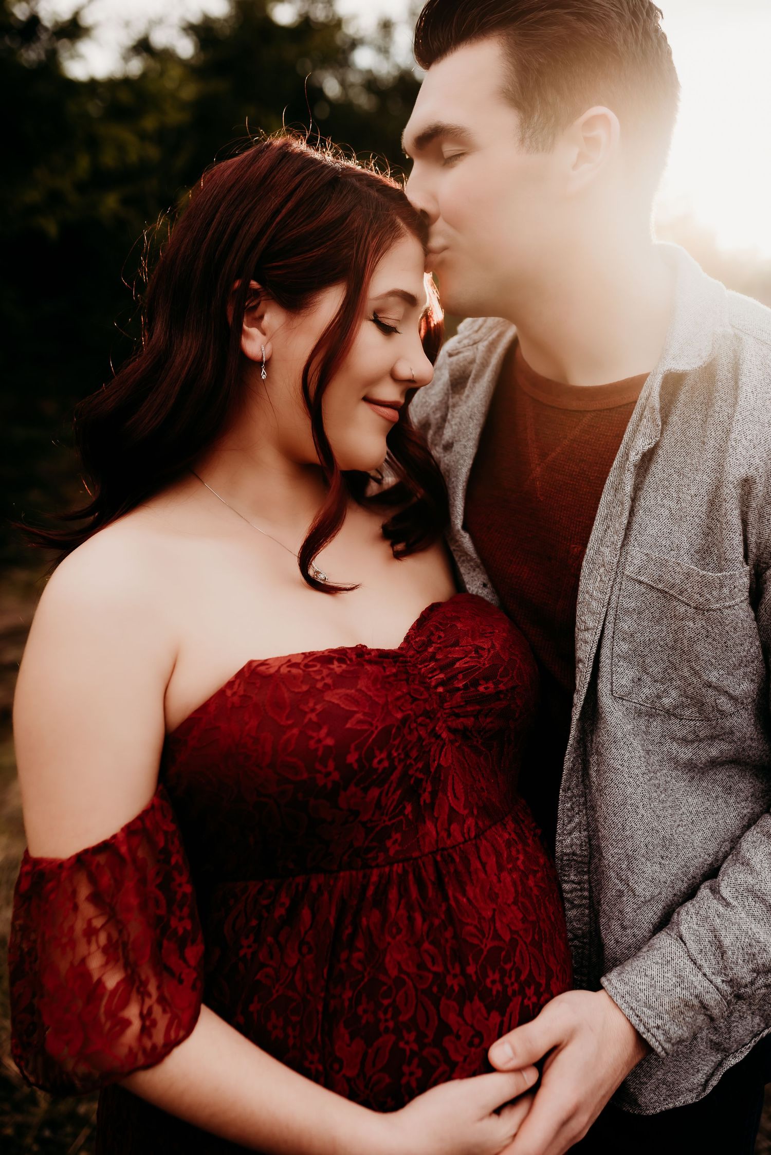 Intimate maternity portrait session at sunset with couple in formal wear.