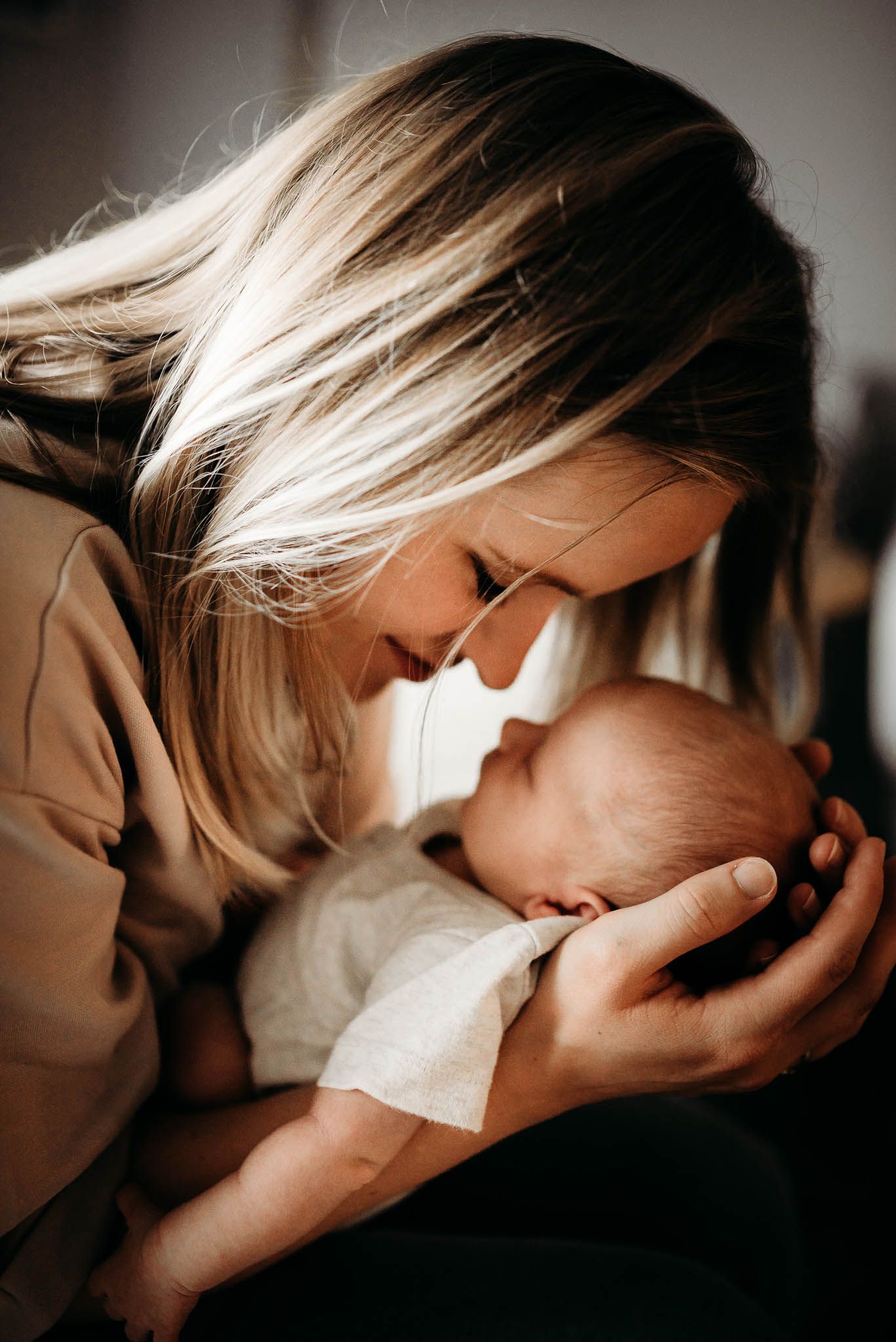 An intimate black and white maternity portrait in soft window light.