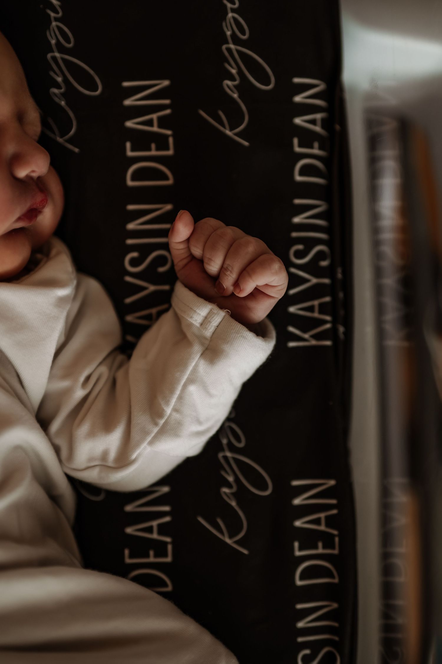 Artistic newborn photography setup with black and white text backdrop.