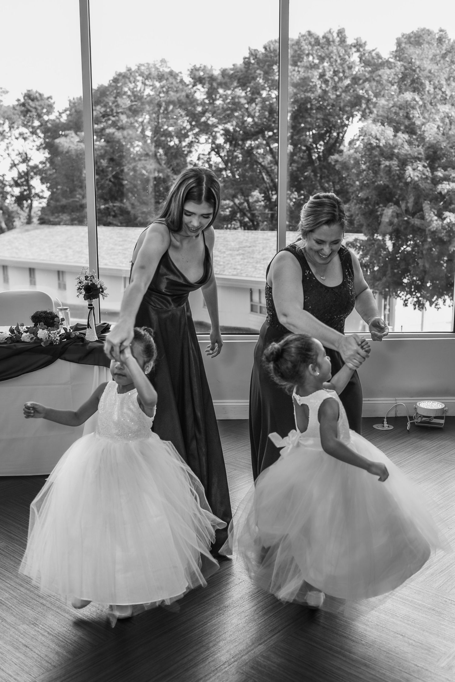 Black and white sequence showing people helping with a bride's dress preparations.