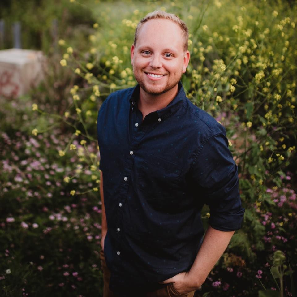 Close-up portrait shots against a green foliage background wearing a navy blue shirt.