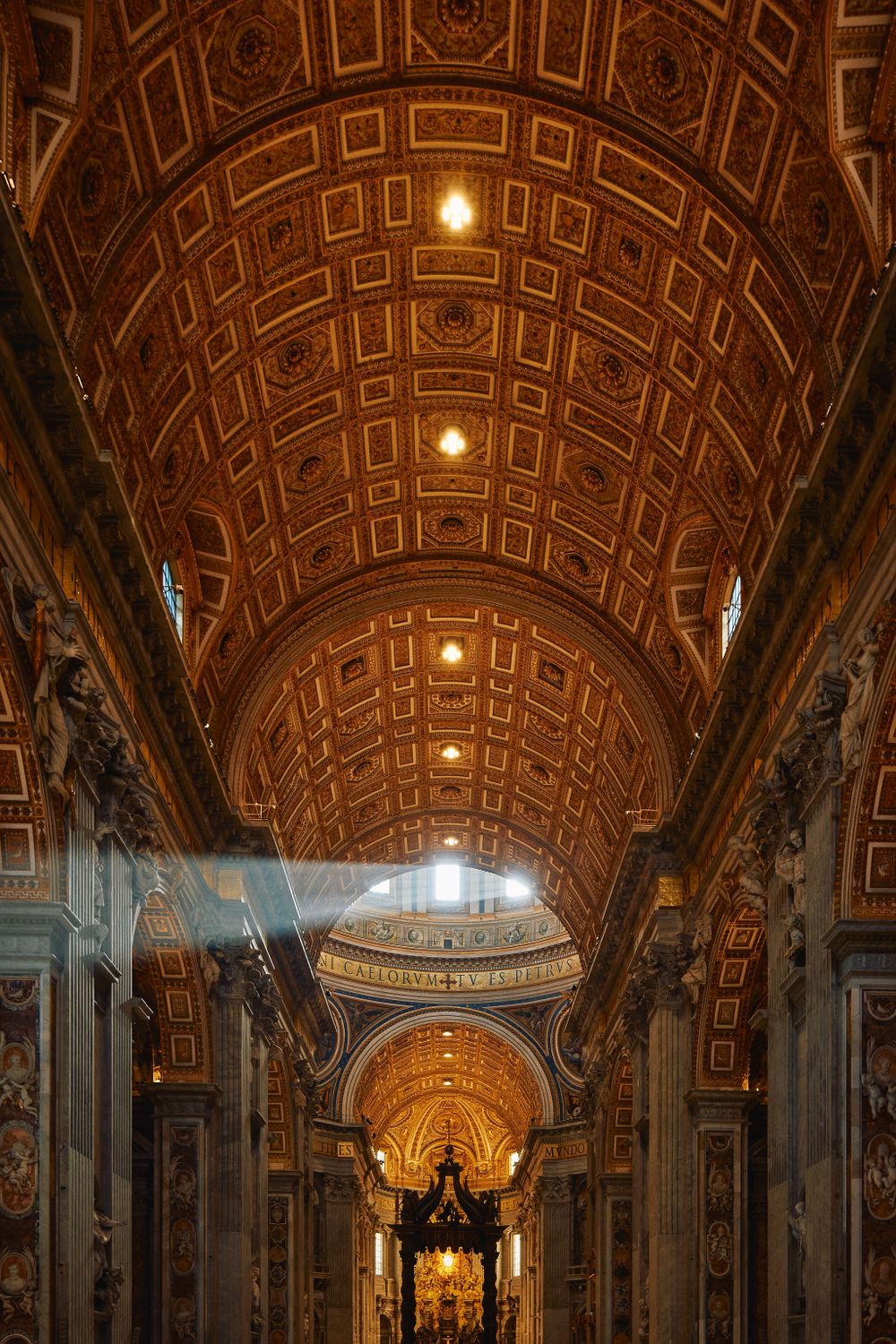 Interior view of Saint Peter's Basilica showing ornate coffered ceiling and sunbeams streaming through windows in Vatican City.