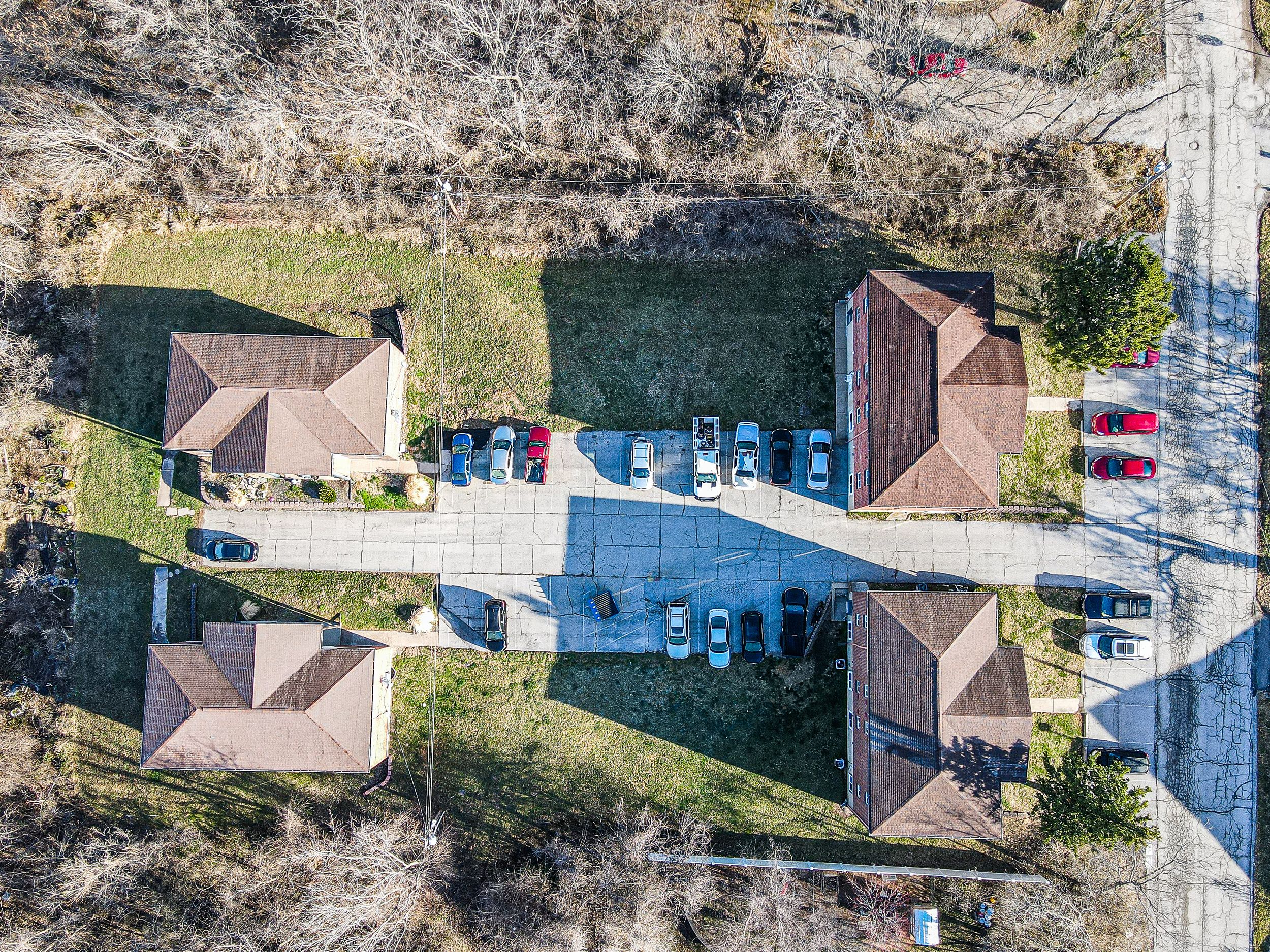 Aerial view of residential properties with connected driveways and landscaped yards.
