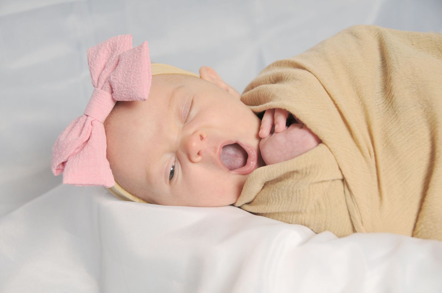 newborn wrapped yawning