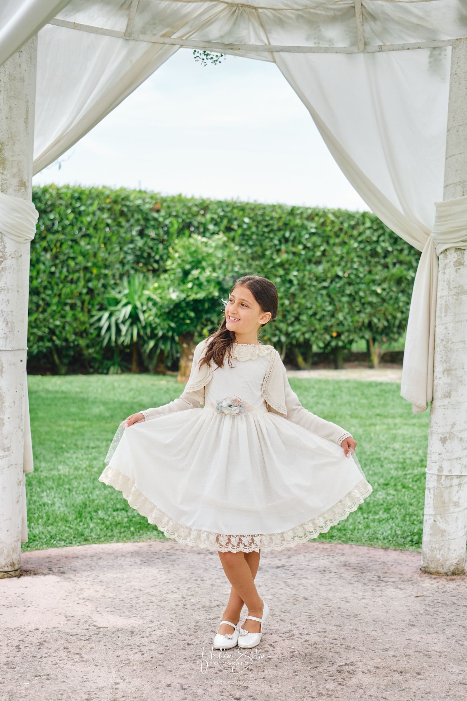 Menina de Comunhão a mostrar o vestido