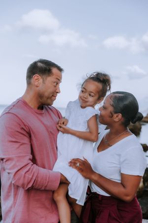 Three people share playful expressions and laughter in an outdoor setting.