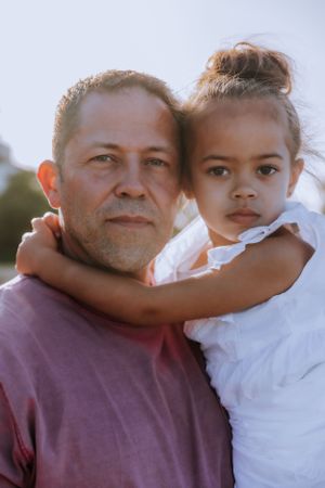 A tender moment shared between parent and child against a bright background.