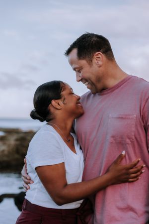 A couple shares affectionate moments while laughing together outdoors.
