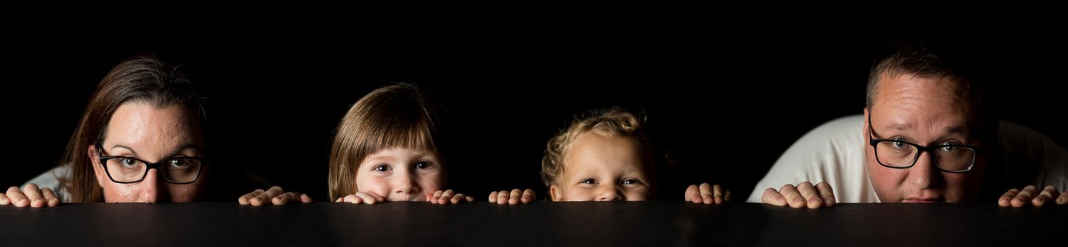 Carlson family peaking over edge.] of table.