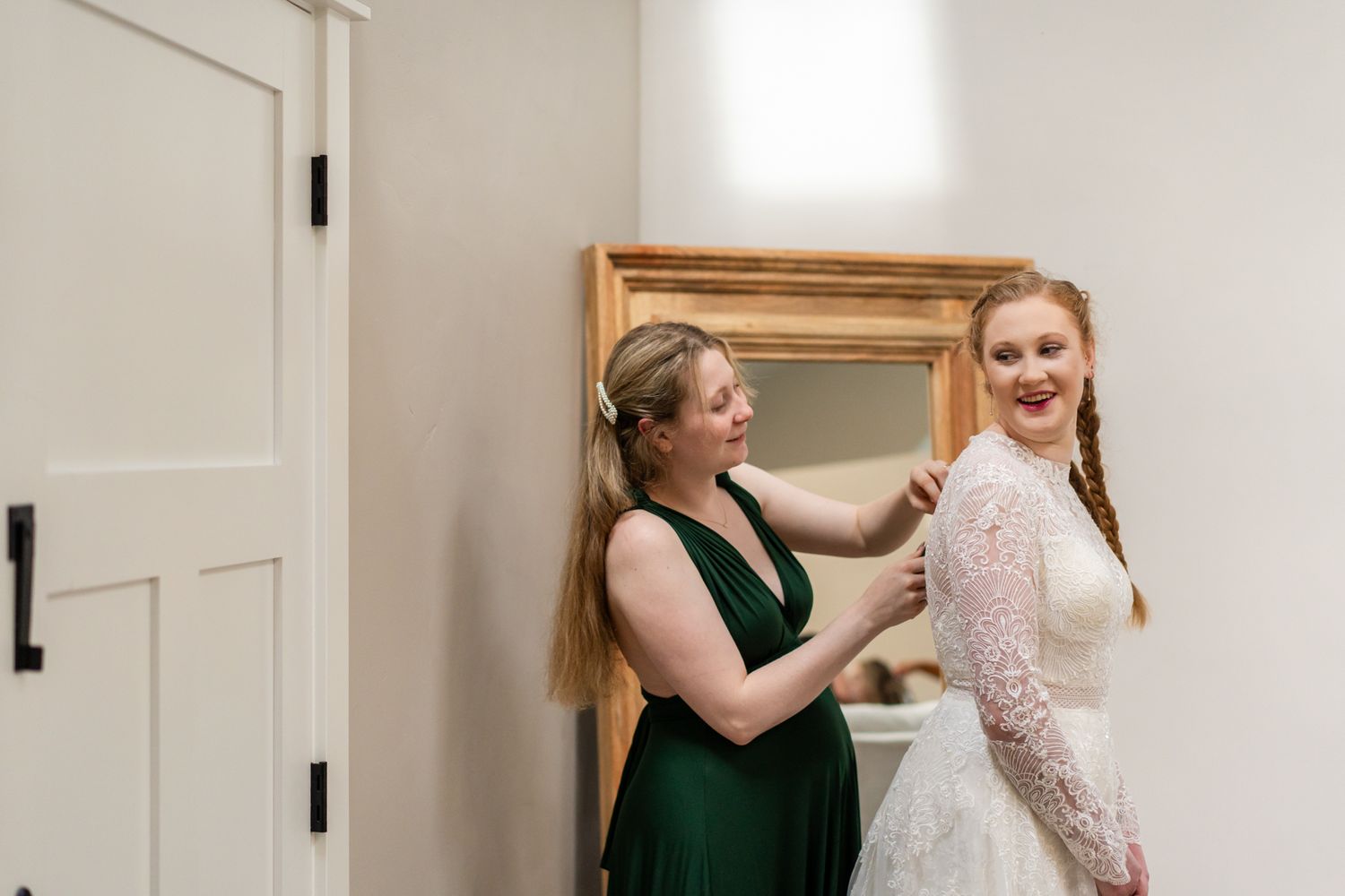 bride's sister and maid of honor helps her get ready