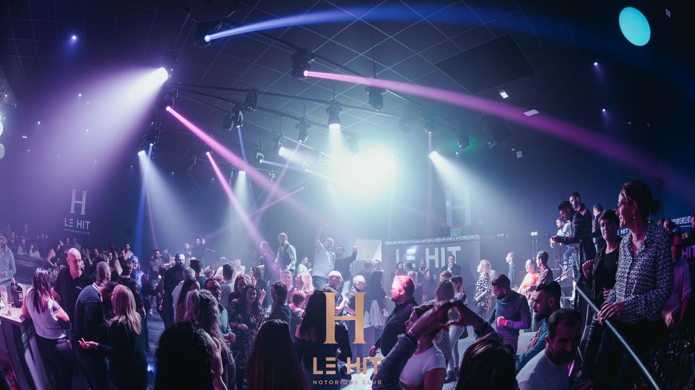 Energetic nightclub crowd under colorful stage lights at Le-Mond venue event.
