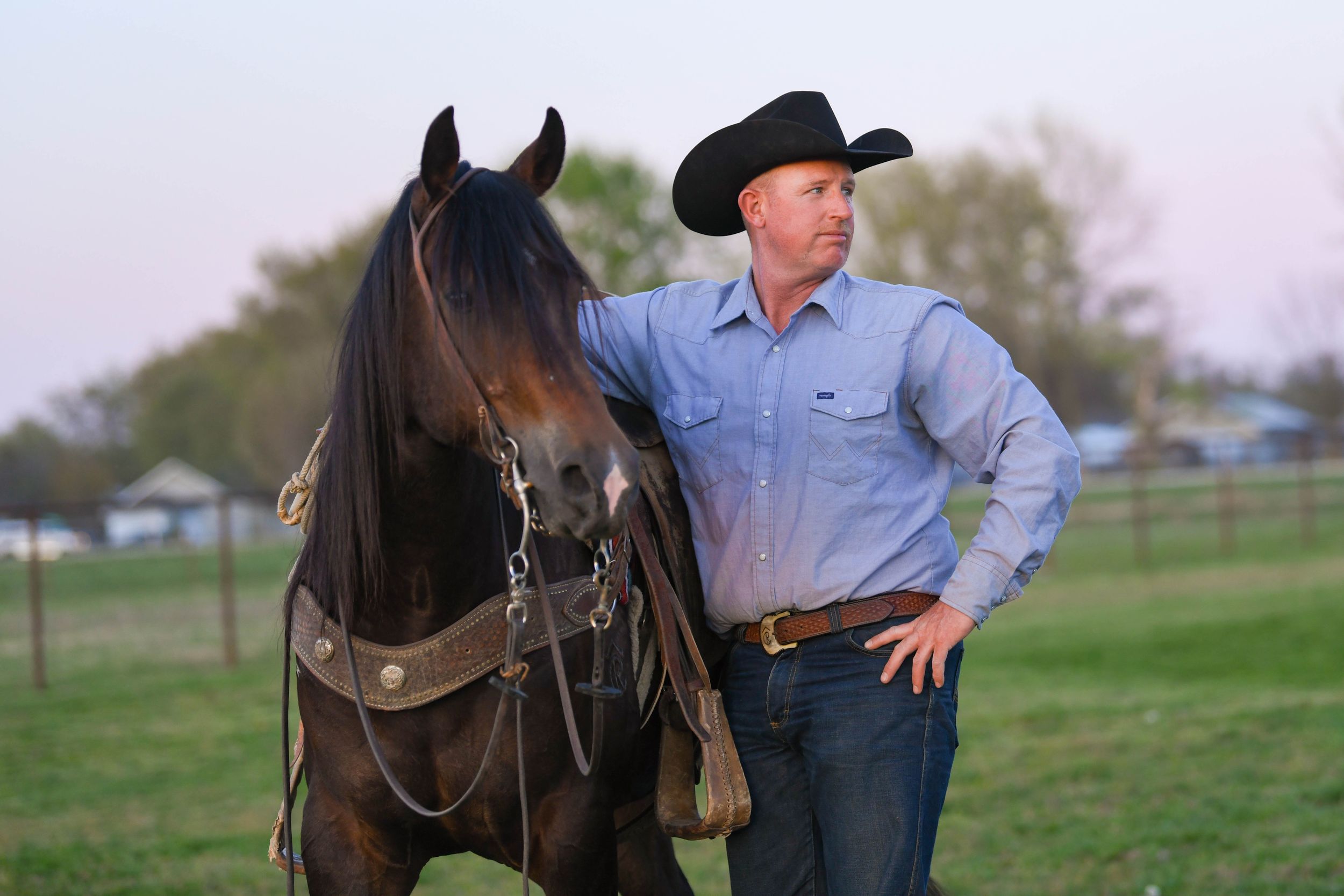 Western-style portrait with horses and riders in traditional cowboy attire.