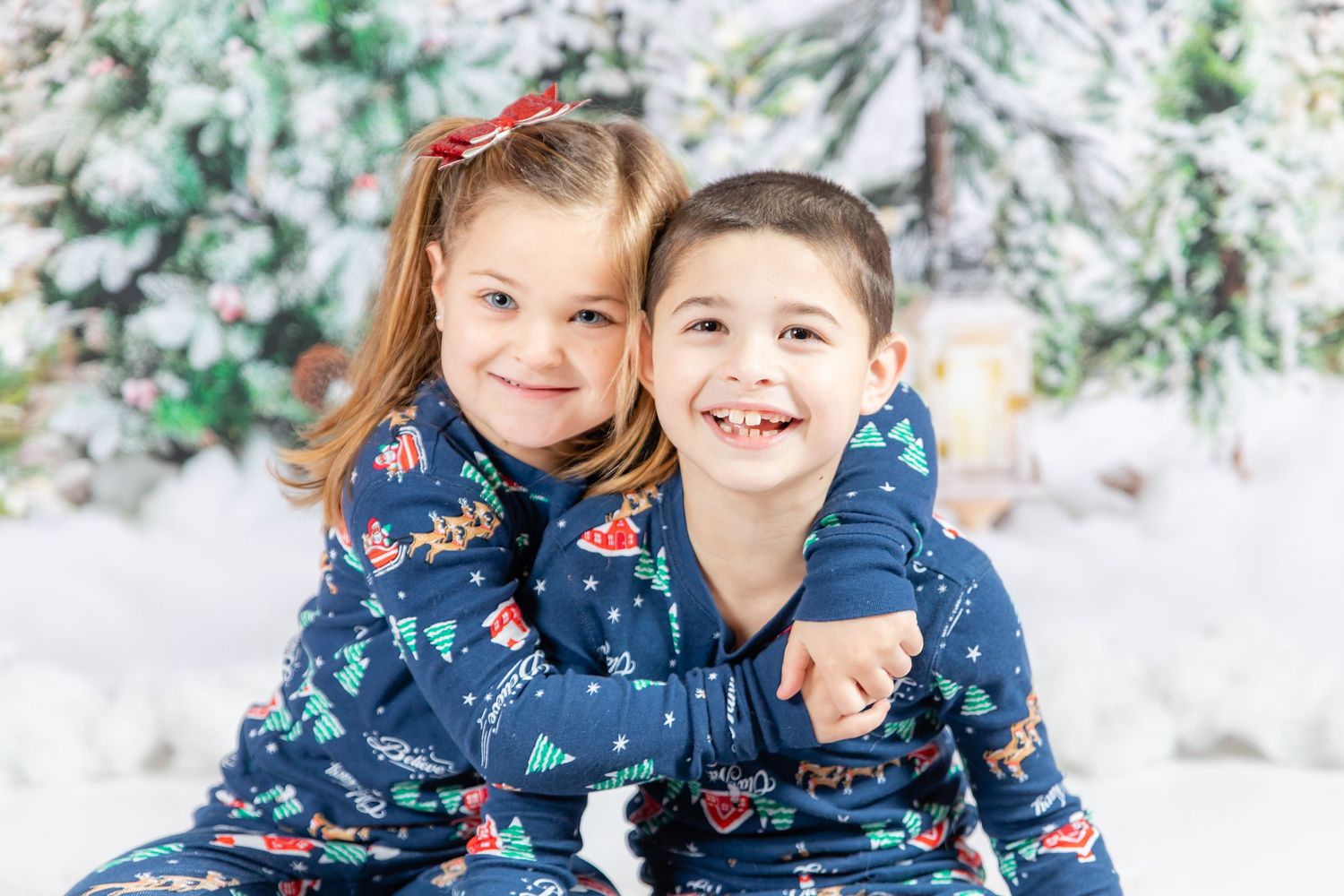 siblings children in studio on tree backdrop with fake snow in christmas pajamas in clayton new jersey Gloucester