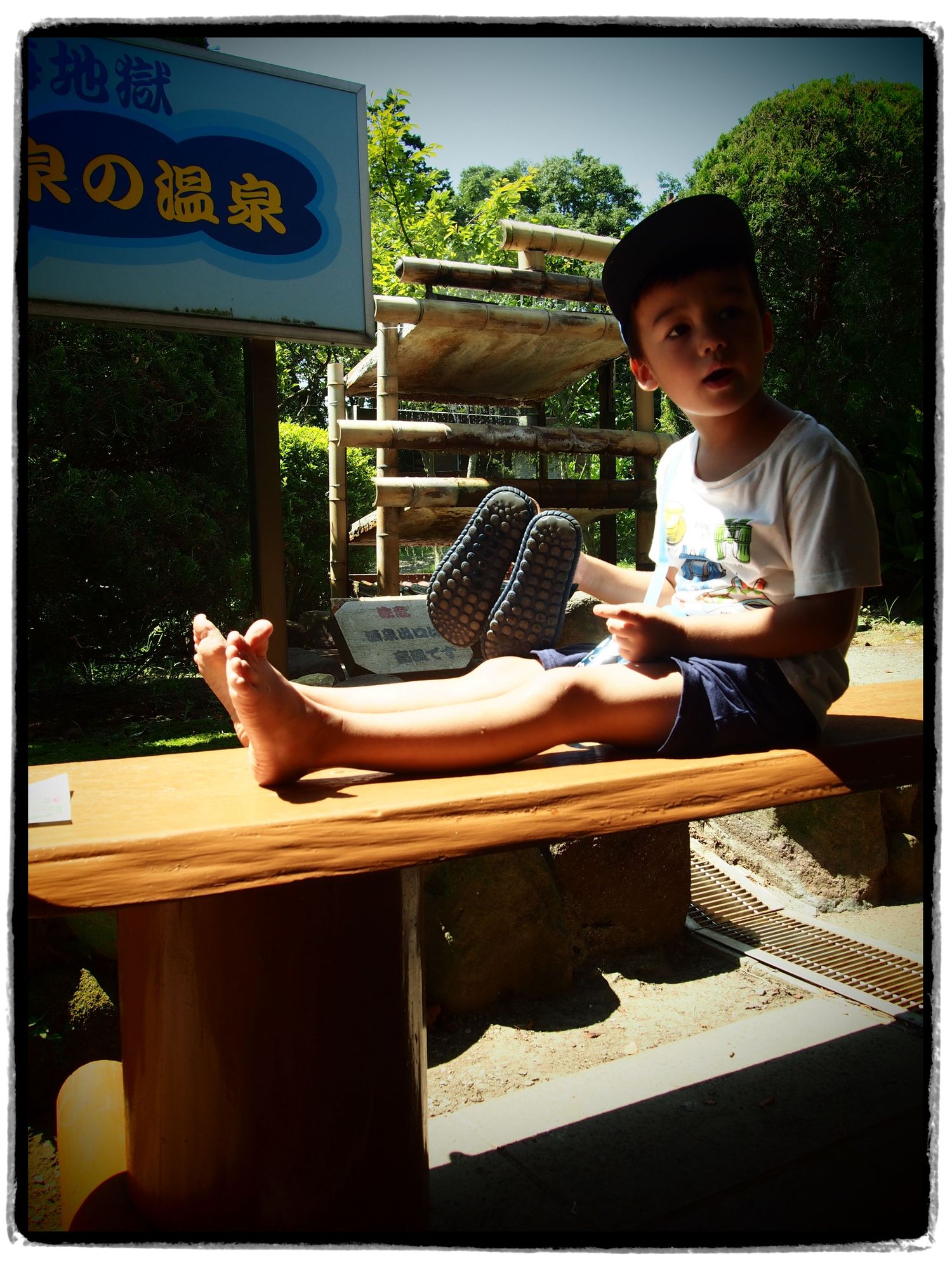 Little man takes off his shoes to paddle in the foot bath in Beppu, resort town in Kyushu Japan @wmlamont