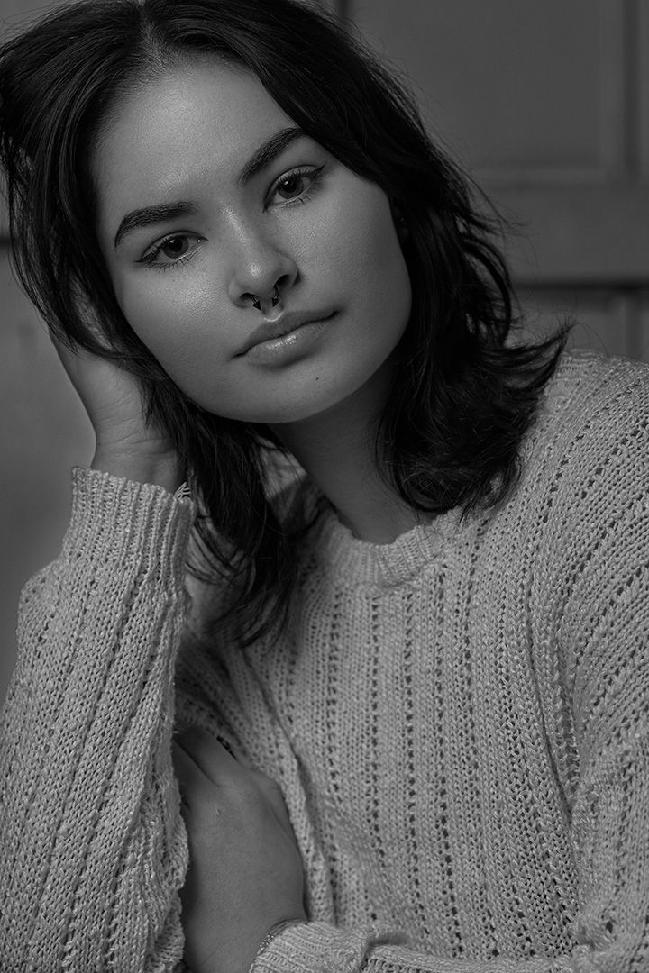 Intimate black and white portrait of someone in cable knit sweater with soft natural lighting.