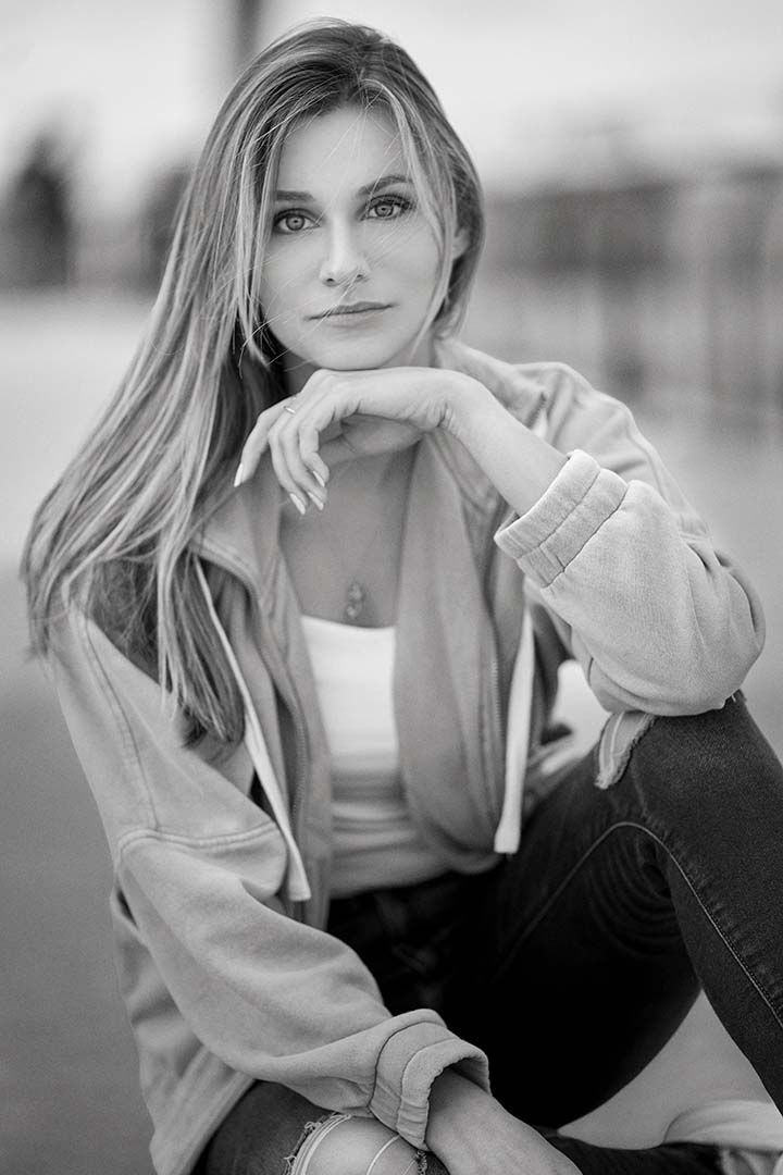 Black and white portrait of someone in casual attire with a gentle pose.