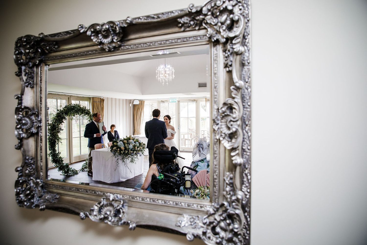 Bride and groom reflection during wedding ceremony in Garden Room at Kelham House