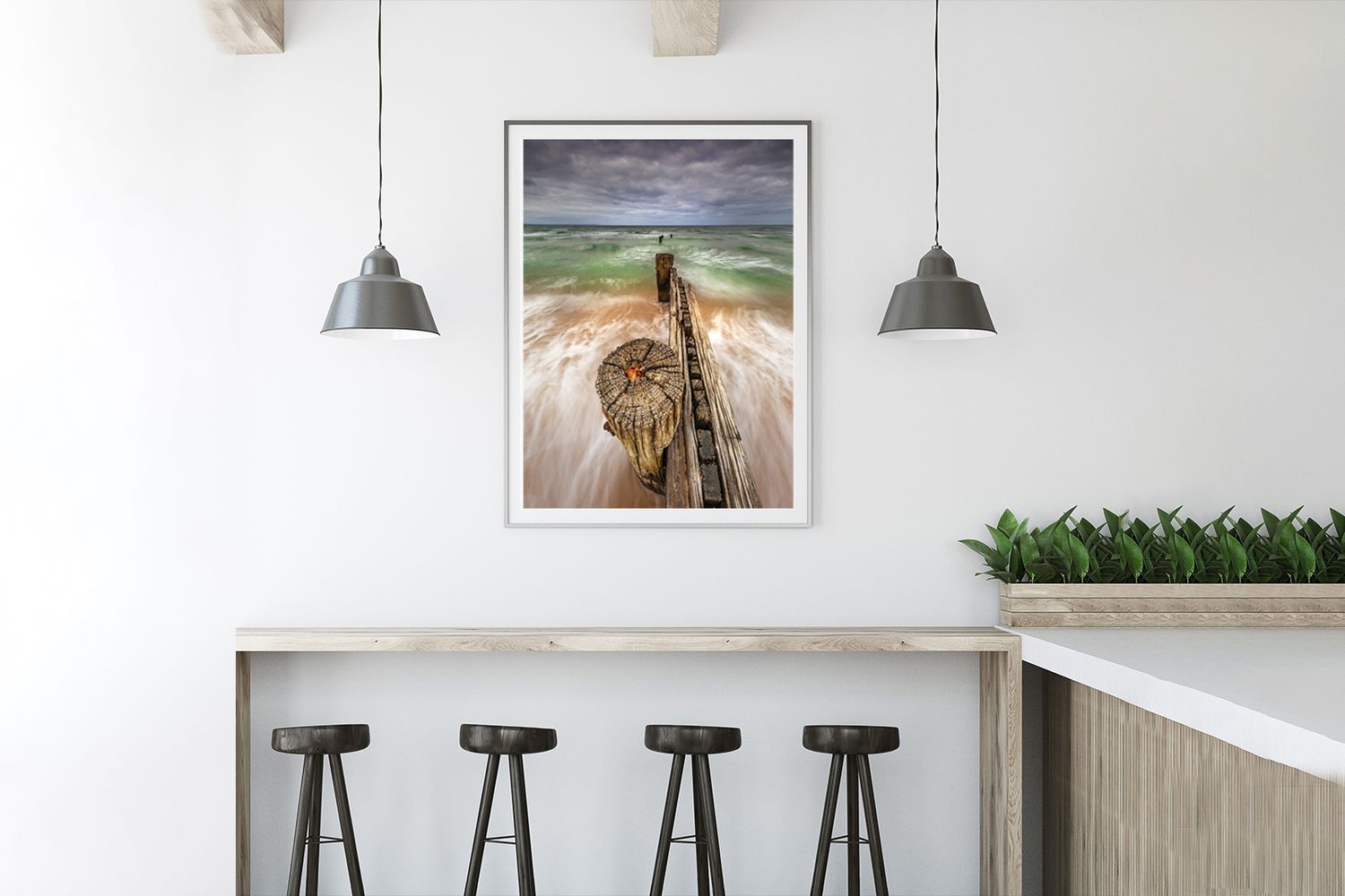 Contemporary kitchen bar design with framed coastal artwork and industrial pendant lighting.