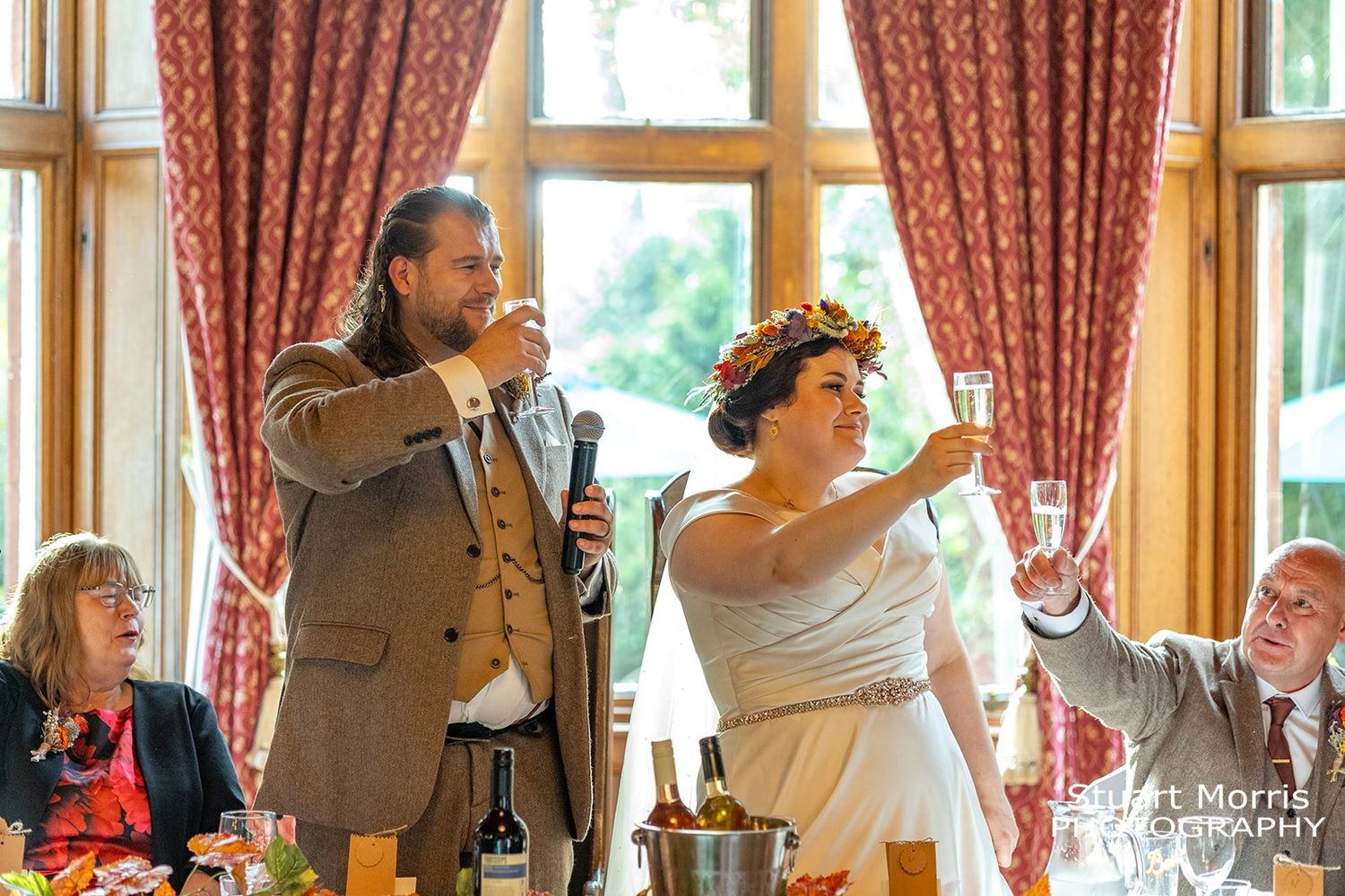 bride and groom raise a glass in a toast in the banqueting room at ruthin castle. Stuart Morris Photography.