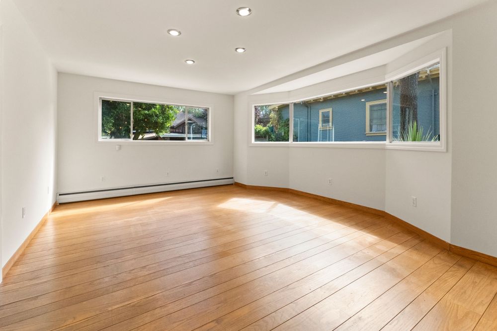 Contemporary living room interior with vaulted ceiling and large windows.