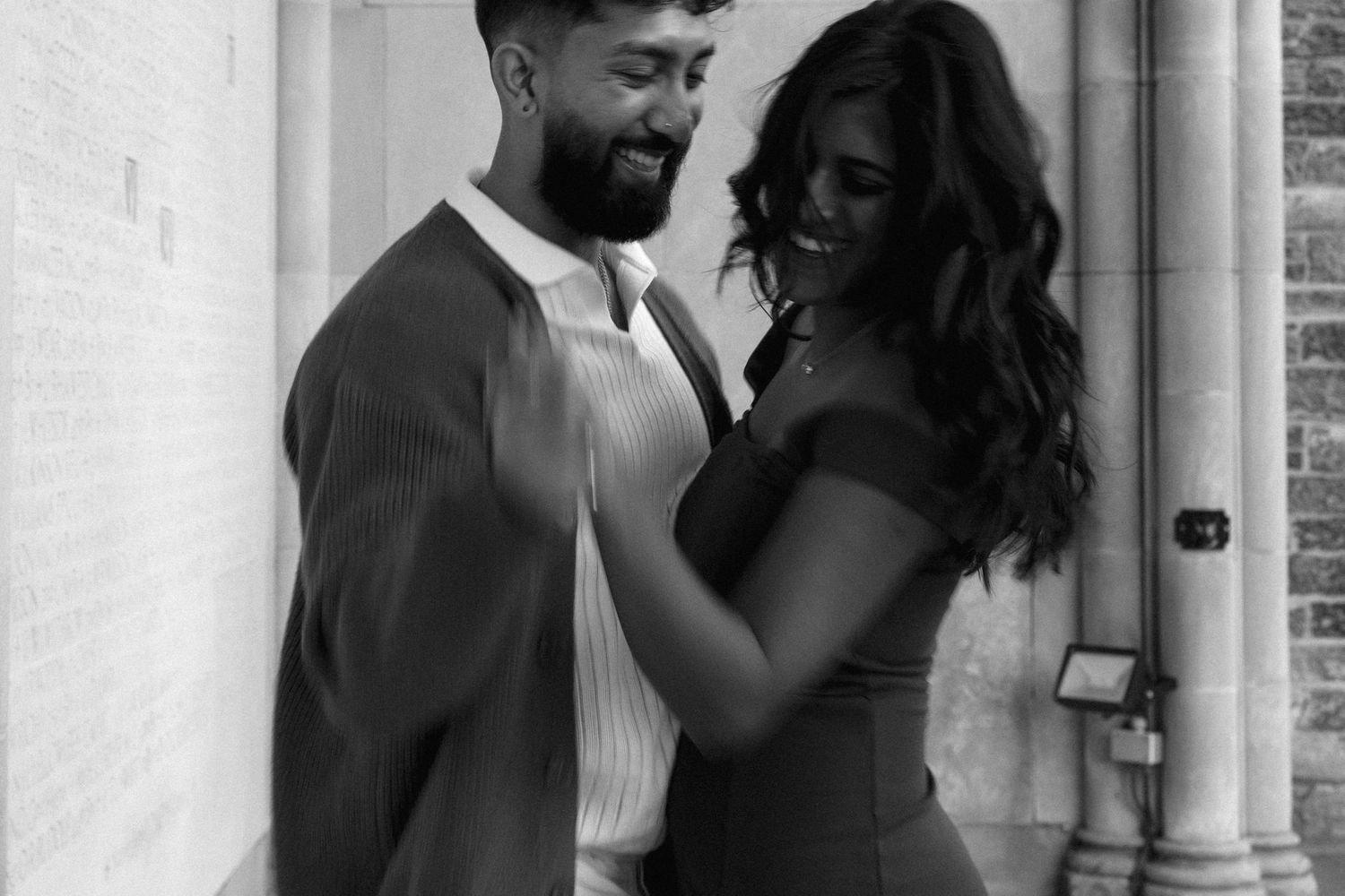 Black and white portrait of a stylishly dressed couple sharing an intimate moment.