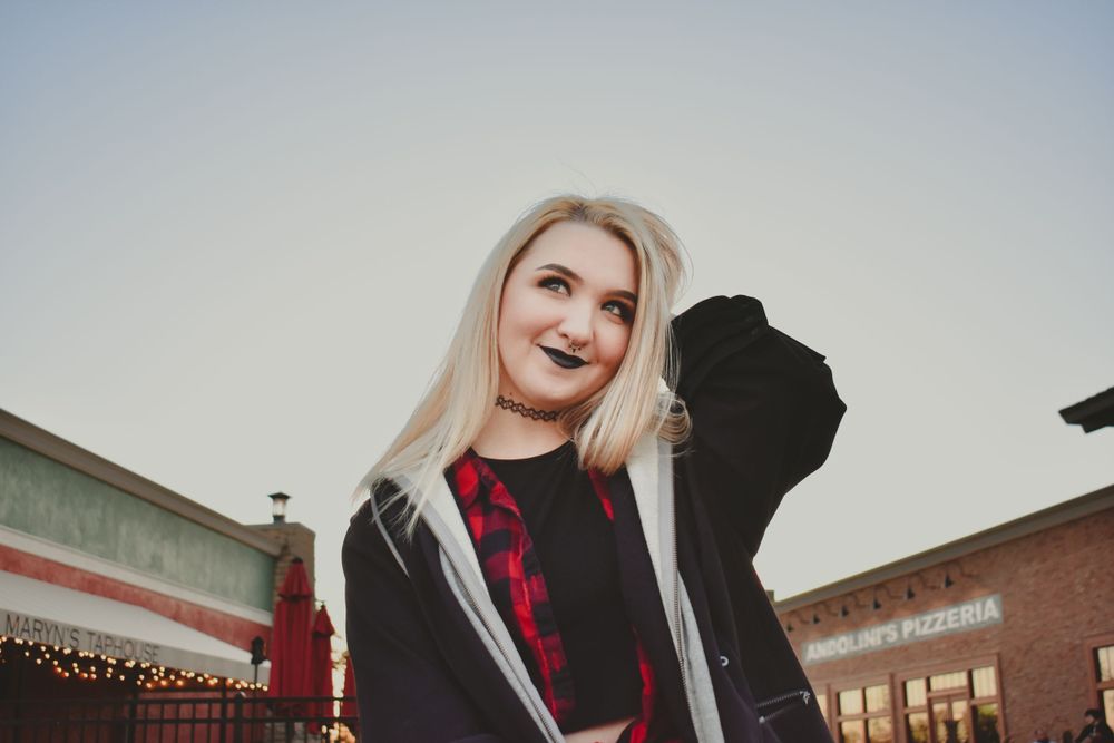 A young woman smiles cheekily as she poses in Jenks, Oklahoma