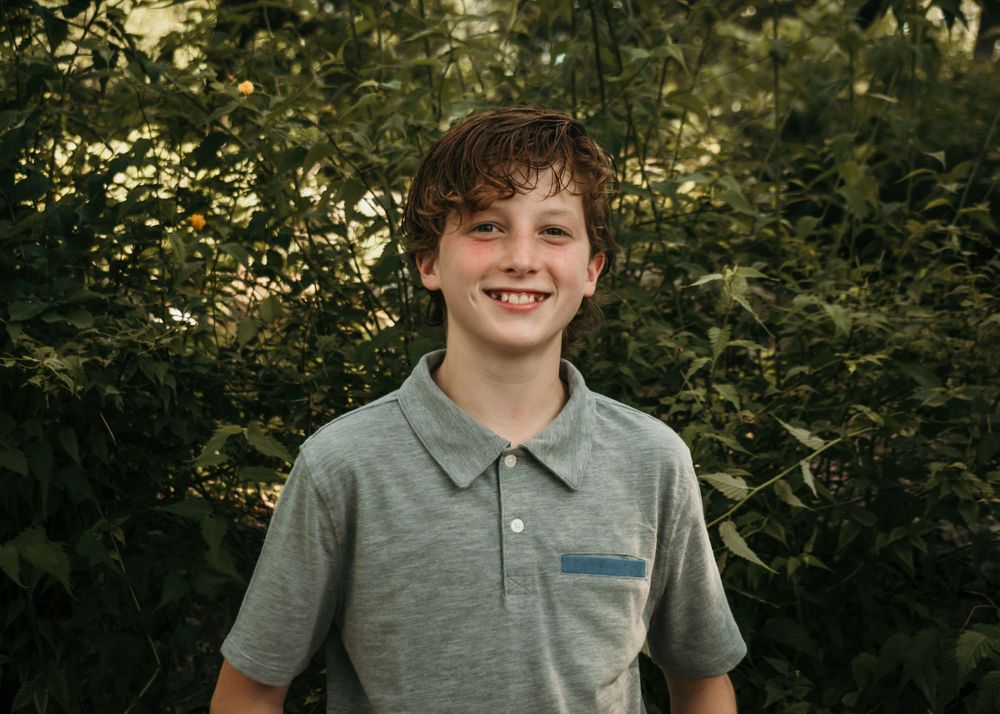 A tween boy asks for a photo of just himself during a family photo shoot