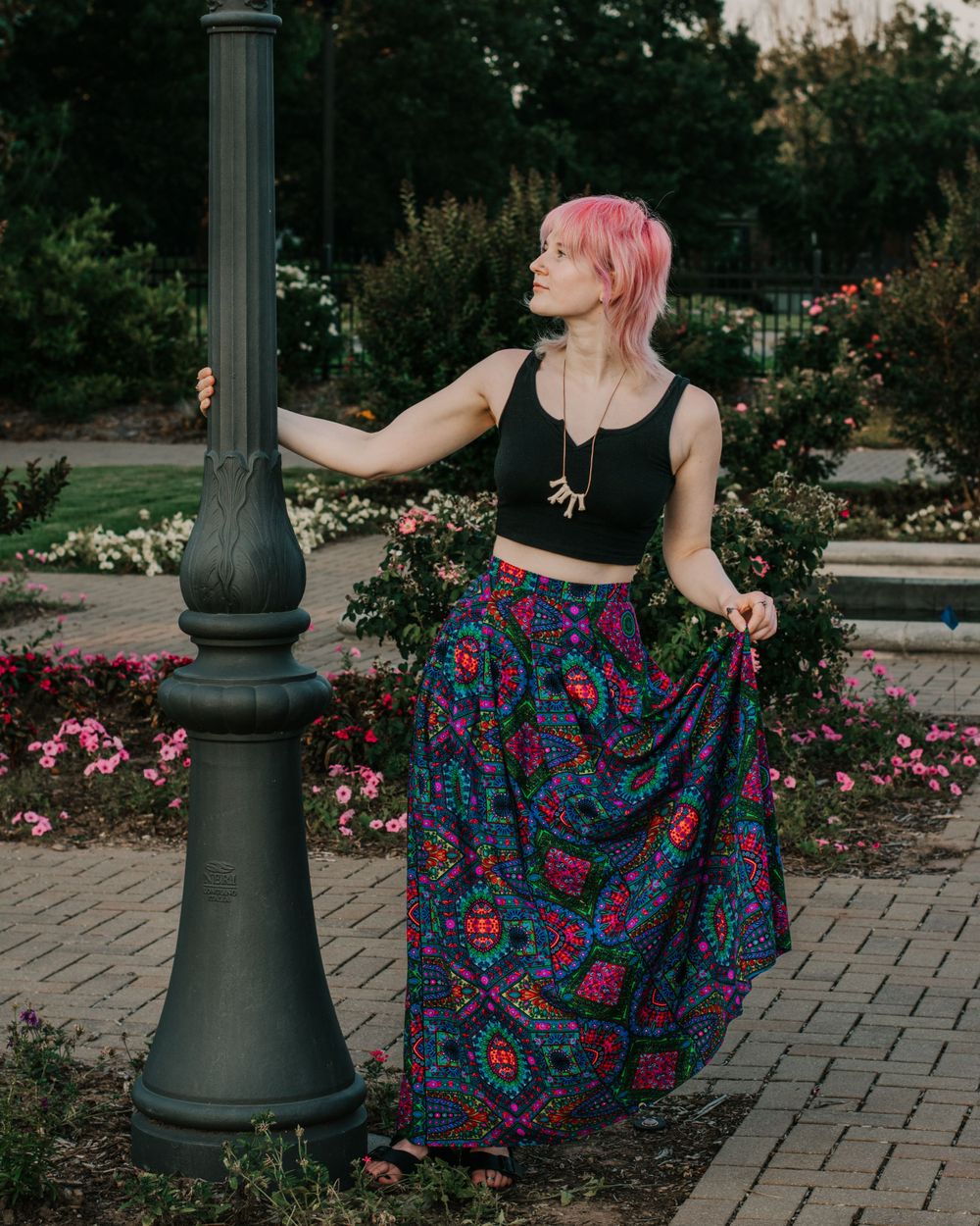 A young woman dances around a pole, taking in the summer evening