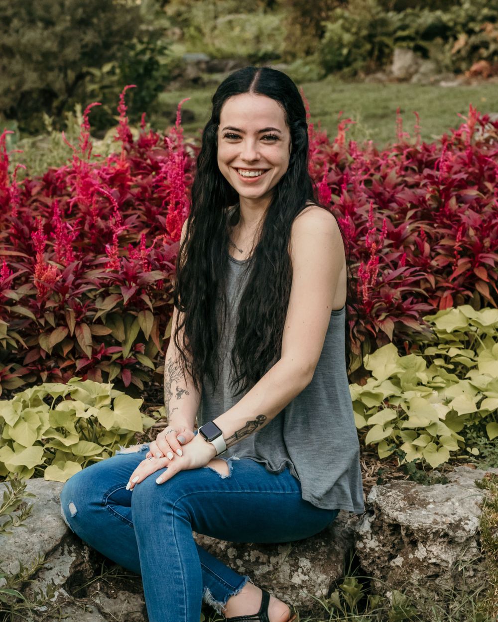 A young woman poses happily for senior photos