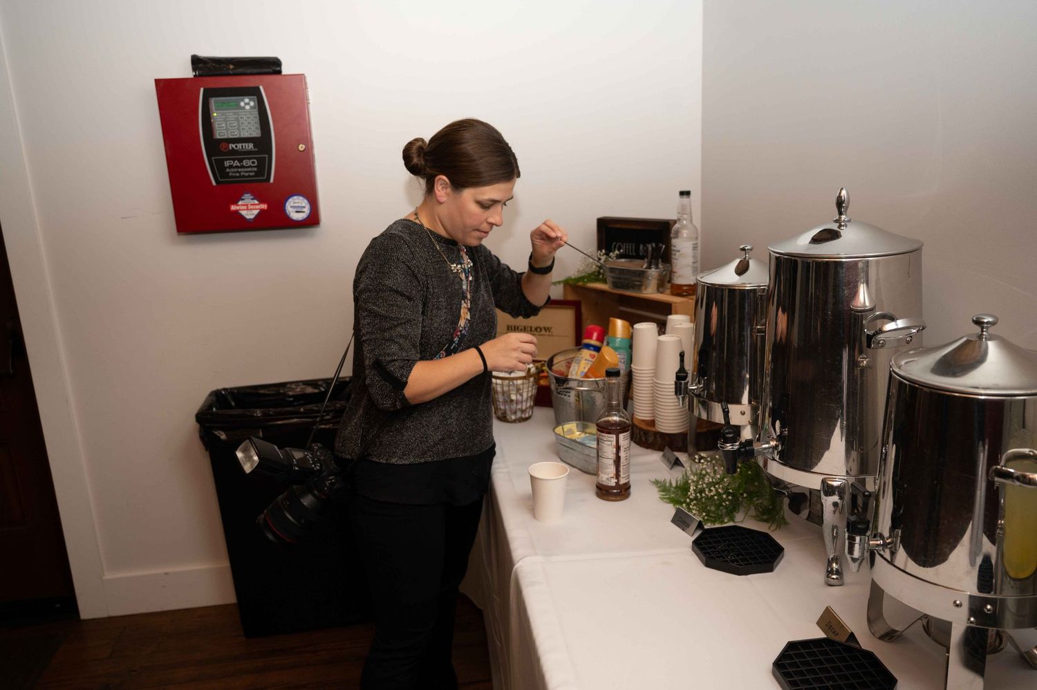 A coffee station setup with large dispensers and supplies being prepared by staff.
