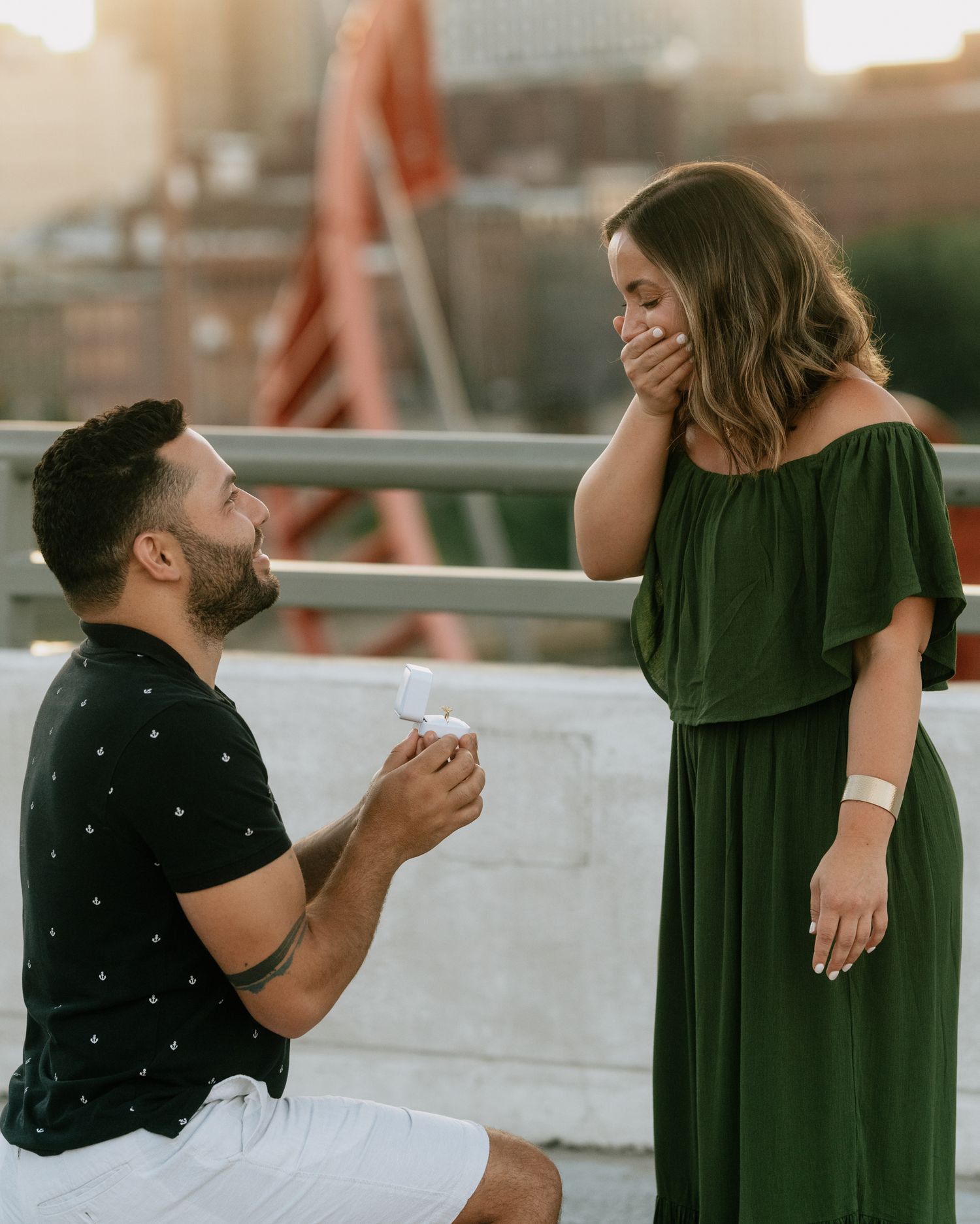 A couple shares a romantic moment on a rooftop during a marriage proposal.