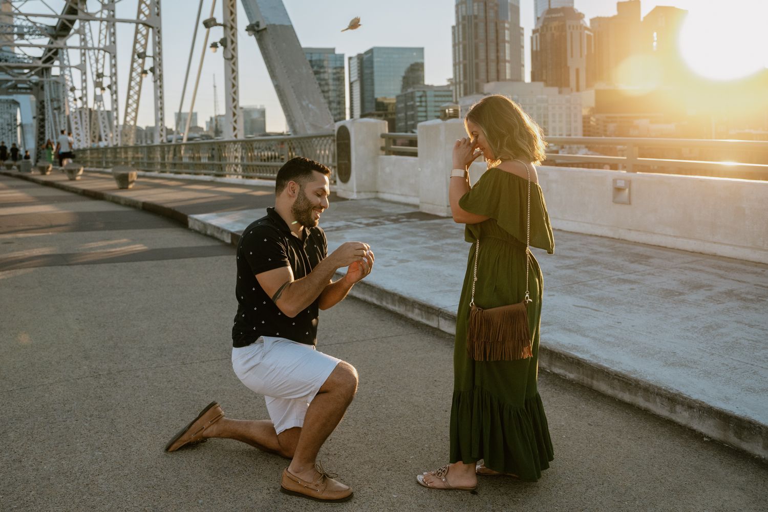 A heartfelt marriage proposal takes place on a bridge with Nashville's skyline in the background.