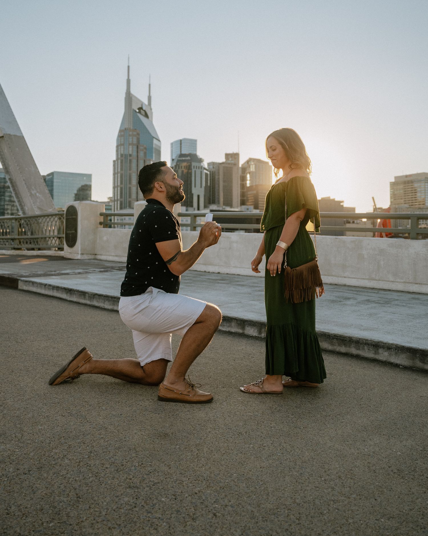 A sunset proposal moment captured on an urban rooftop with the Nashville skyline visible.