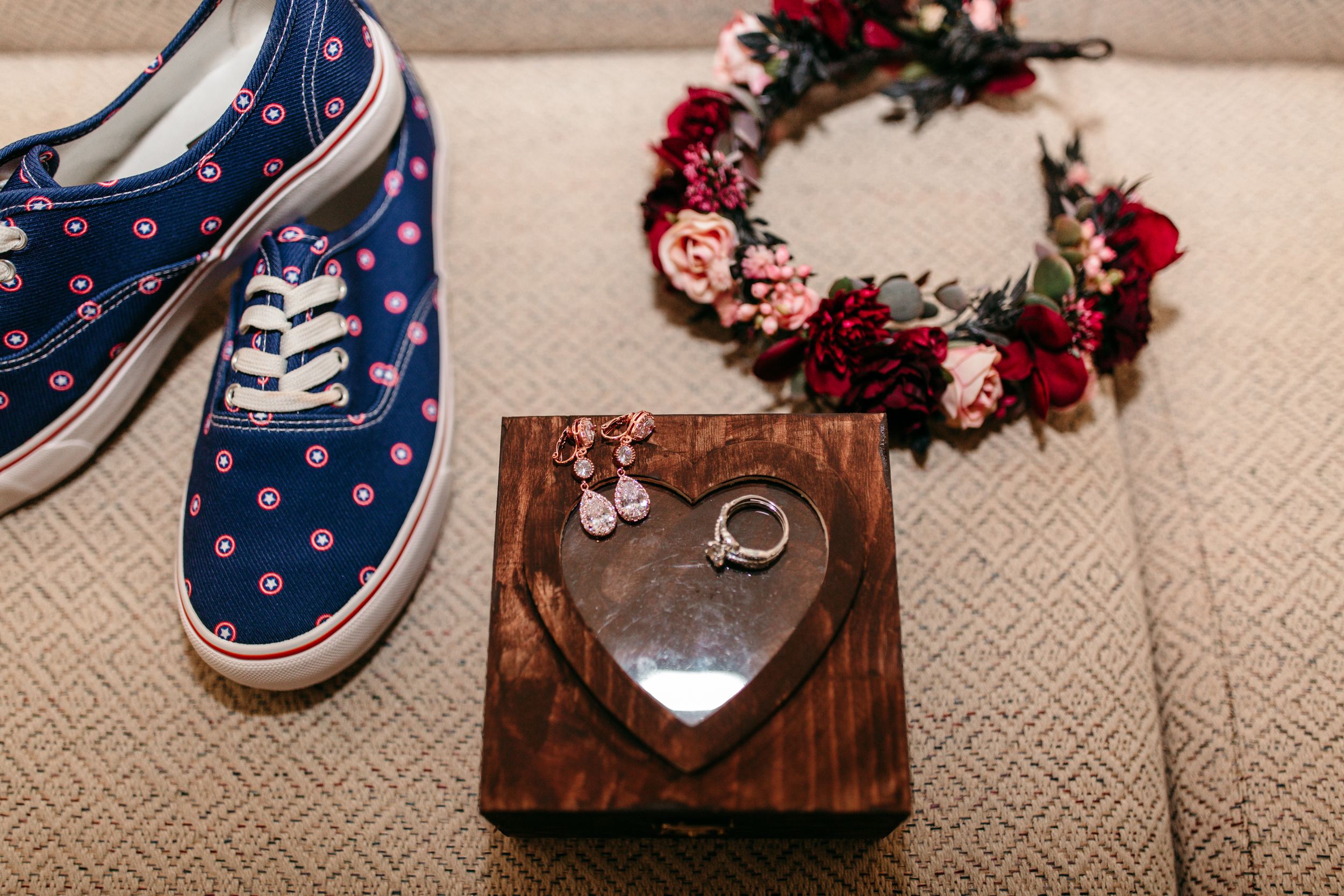 Blue polka dot sneaker next to a Christmas wreath and wooden heart-shaped box.
