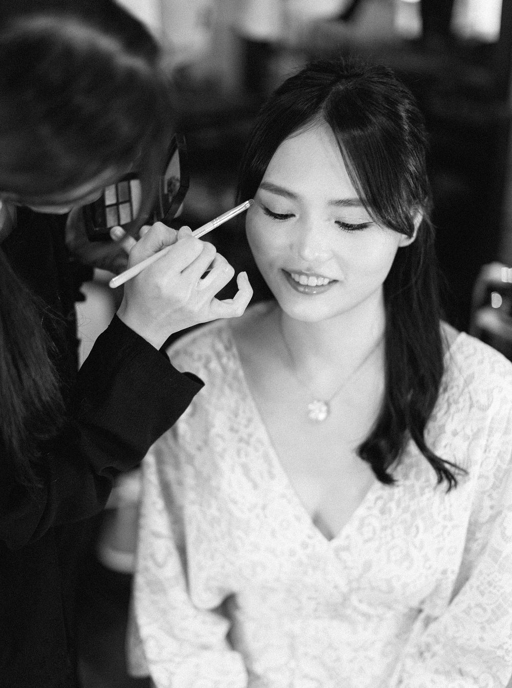 A bride in Phuket, Thailand, having her makeup done by another woman.