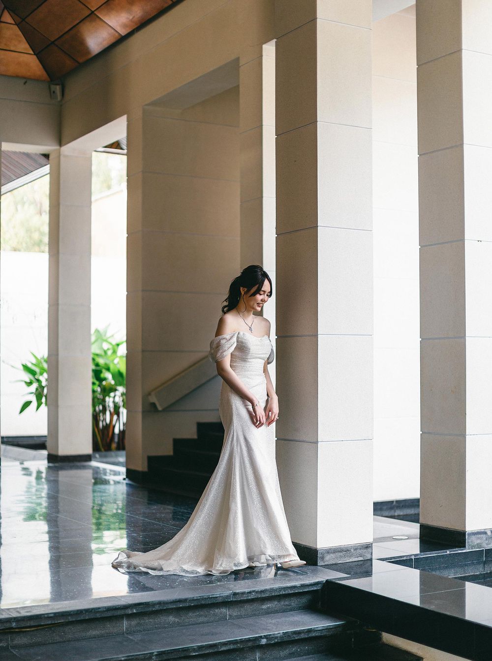 Bride in white dress at Phuket, Thailand, walking in reception of Paresa Resort.