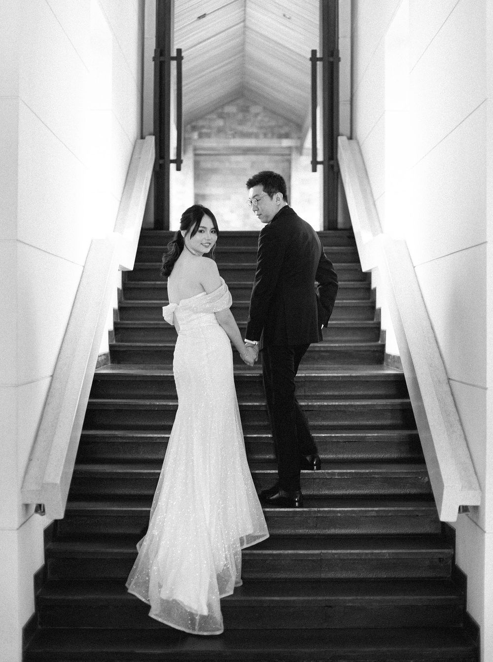A bride and groom walking down stairs at their wedding at Paresa Resort, Phuket, Thailand.